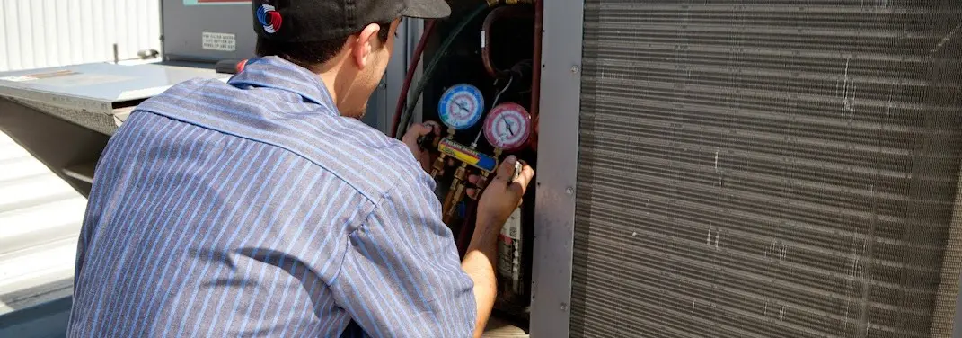 HVAC technician servicing a condenser unit in Hoquiam